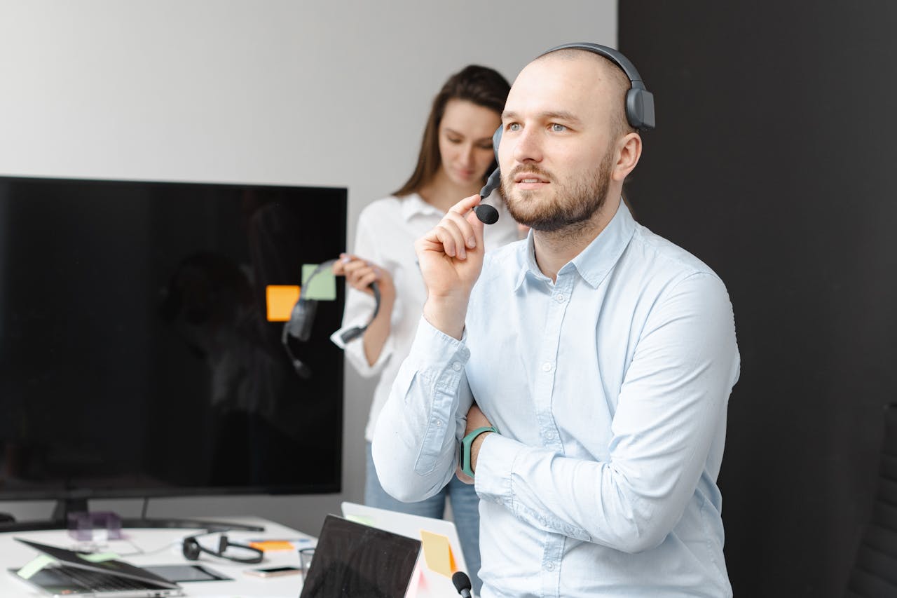 A focused customer service agent using a headset in a modern office environment.